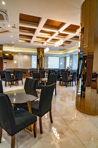 a restaurant with chairs and tables in a lobby at Hotel Don Ruben Business And Suites Juventud Chihuahua in Chihuahua