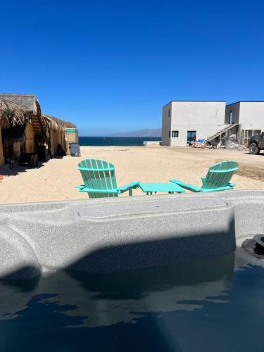 two chairs sitting on the beach next to the water at Private Jacuzzi Suite Steps to the Beach in La Ventana