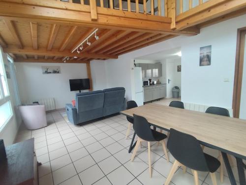 a living room with a large wooden table and chairs at Appartement 3 Chambres Bollezeele in Bollezeele
