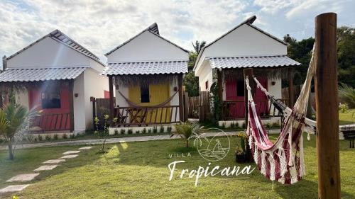 twee huizen met een hangmat ervoor bij Villa Tropicana in Saubara