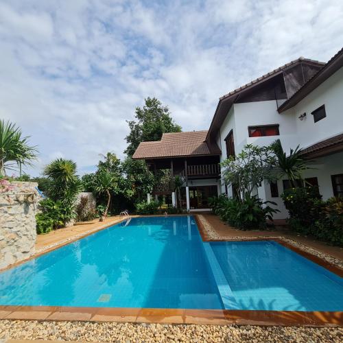 a swimming pool in front of a house at Clear Water Pool Villa in Mu Si