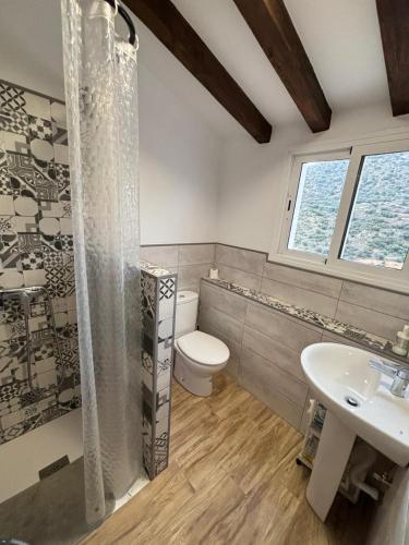 ein Badezimmer mit Toilette und Waschbecken in der Unterkunft El pajar in Laroya