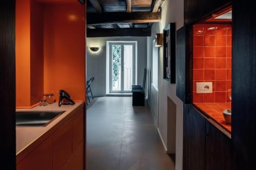 una cucina con pareti arancioni e un lavandino e un corridoio di House of Allora a Roma