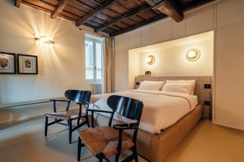 una camera da letto con un letto grande e due sedie di House of Allora a Roma