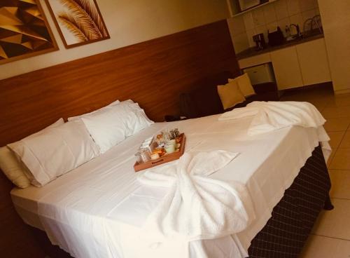 a large white bed with a wooden head board at Suíte luxo com tela de cinema no América Towers Studio Residence in Salvador