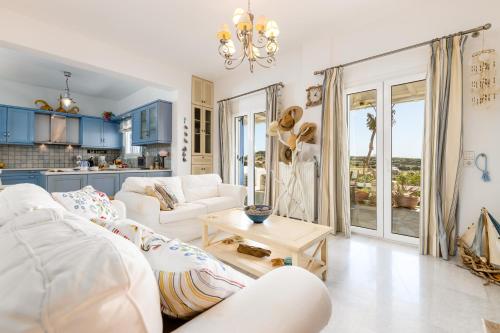 a living room with a white couch and a table at Villa Meliti Paros in Angairiá