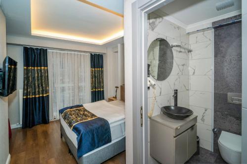 a bedroom with a bed and a bathroom with a sink at Hotel Martini in Istanbul