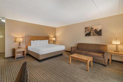 a hotel room with a bed and a couch at Best Western Plus Waltham Boston in Waltham