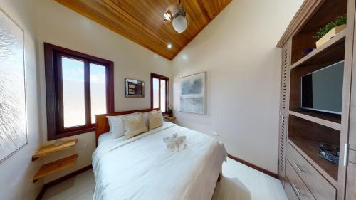 a bedroom with a white bed and a tv at Enjoy Savings Oceanfront Private Estate By Alom in San Pedro