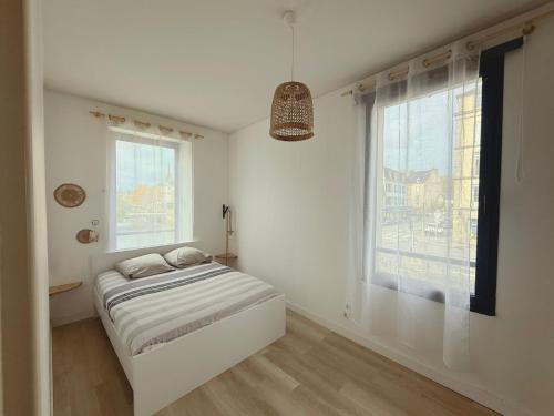 a white room with a bed and two windows at Quimper: T3 avec vue cathédrale proche gare in Quimper