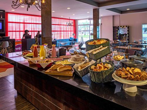 a buffet with bread and pastries on a table at Golden Tower Express Braz Olaia by Fênix Hotéis in Ribeirão Preto