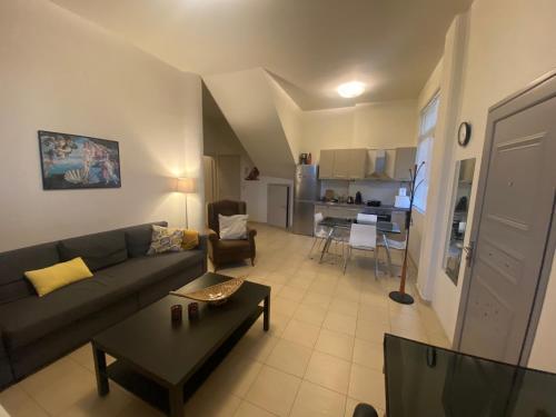 a living room with a couch and a table at Nefele - Athens Airport Home in Artemida
