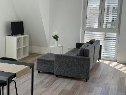a living room with a couch and a tv at Ferienwohnung mit Balkon in Steinhagen in Steinhagen