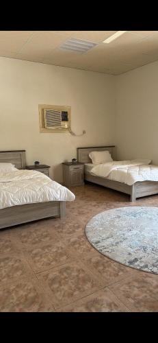 Un dormitorio con dos camas y un ventilador. en Crestora farm, en Ras al Khaimah