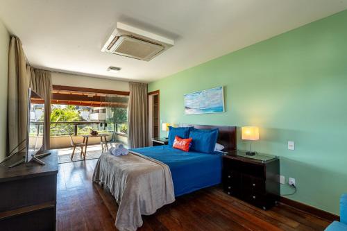 a bedroom with a blue bed and a television at Mansão em Niterói com Piscina e Vista Mar | LD 58 in Icaraí