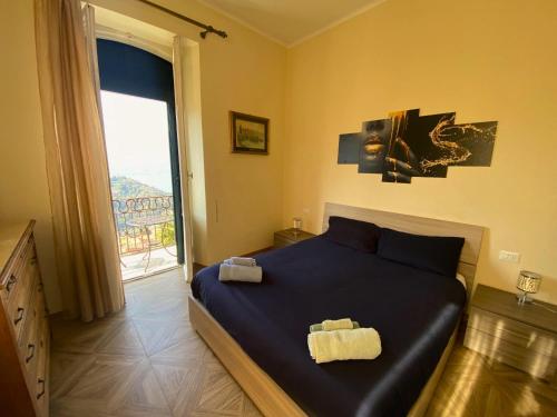 a bedroom with a large blue bed with a window at Villa Silvana in Perledo