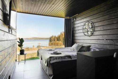 una camera da letto con un letto e una grande finestra di Maisemasviitit Ellivuori Resort a Karkku