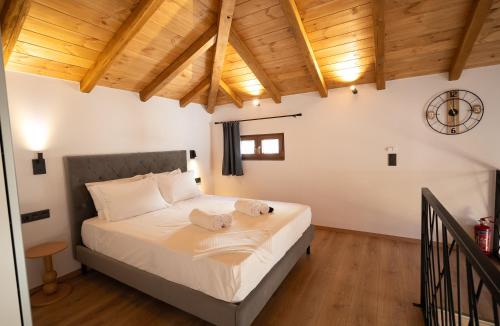 a bedroom with a bed with a clock on the wall at Korifes Meteora lithari 01 in Kalabaka