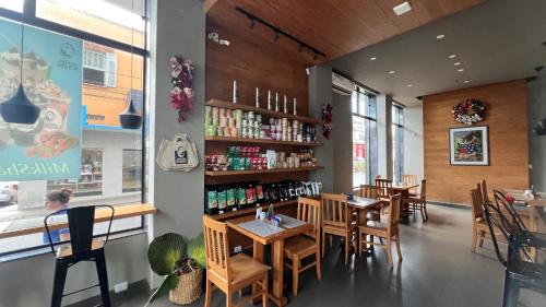 a restaurant with wooden tables and chairs and a book shelf at Hotel Dourado in Alfenas