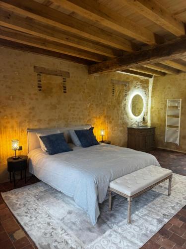 a bedroom with a large bed in a stone wall at Le Relai Valdieu in Courgeon