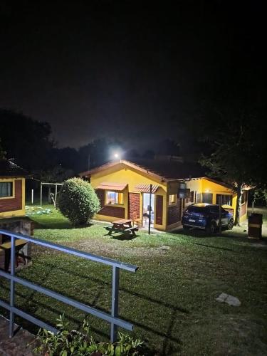 a house with a car parked in front of it at night at Cabañas Sensaciones Serranas in Casa Grande