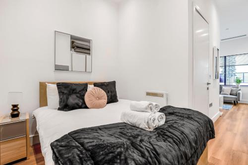 a bedroom with a large bed with towels on it at The Cosy Luxe in Slough