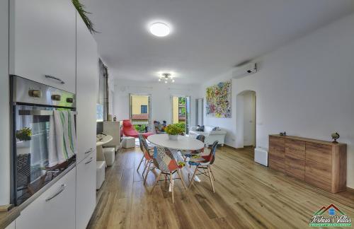 a kitchen and living room with a table and chairs at Casa Giuditta with Air Conditioning and Pool in Lierna