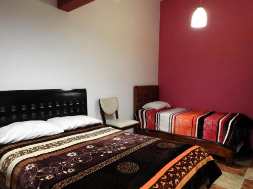 a hotel room with two beds and a chair at MJ Habitaciones Cholula in La Concepción