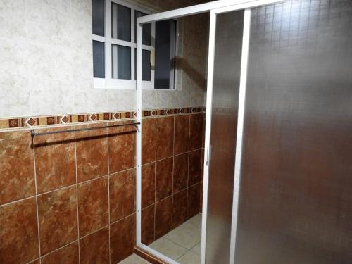a shower with a glass door in a bathroom at MJ Habitaciones Cholula in La Concepción
