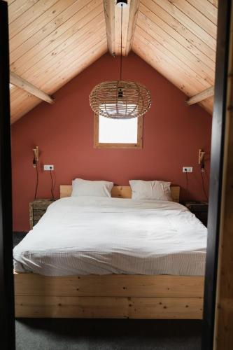 a bedroom with a large bed in a attic at Hof Driewegen in Driewegen