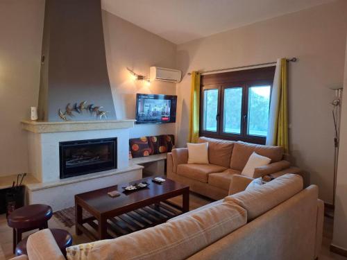 ein Wohnzimmer mit Couch und Kamin in der Unterkunft Ioanna's sweet & cozy apartment with sea view in Monemvasia