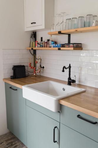 a kitchen with a white sink and white cabinets at Hof Driewegen in Driewegen