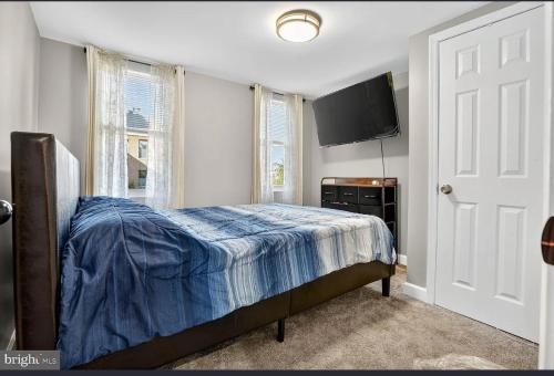 een slaapkamer met een bed en een flatscreen-tv bij Room to Rent in Baltimore