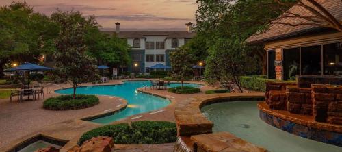 a swimming pool in a resort with a building at Furnished apartments next to the Domain in Austin