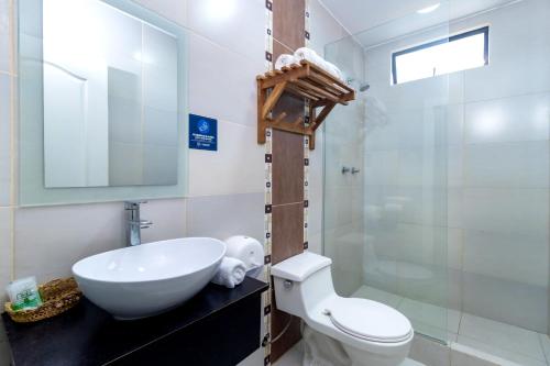 a bathroom with a sink and a toilet and a mirror at Hotel Presidente Beach Salinas in Salinas