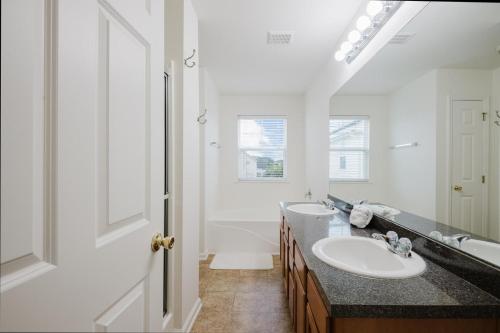 a bathroom with two sinks and a large mirror at Happy in Old Town Bluffton in Bluffton