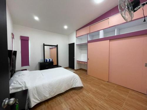 a bedroom with a white bed and a purple wall at Hotel Casa Bendicion in Los Limones