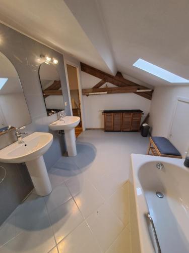 Saint-GoursonにあるLa grange Marieの洗面台2つとバスタブ付きのバスルーム