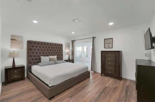 a bedroom with a large bed and a dresser at Spacious 3BR Oasis Pool Fire Pit & Family Fun in Cowley