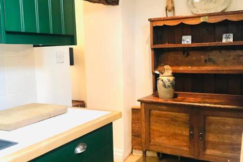 eine Küche mit grünen Schränken und einer Arbeitsplatte in der Unterkunft Mews Cottage off Marlborough High Street in Marlborough