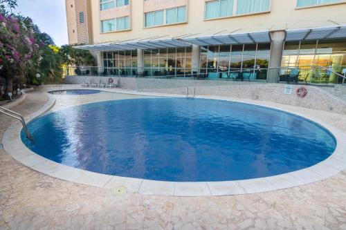 a large blue pool in front of a building at Sonesta Valledupar in Valledupar