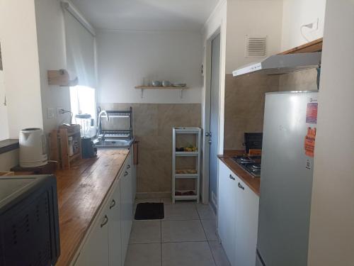 een keuken met witte kasten en een witte koelkast bij Casa en barrio tranquilo in Osorno