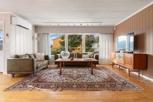 a living room with a couch and a table at Basecamp Dramsvegen Aurora Viewpoint in Tromsø