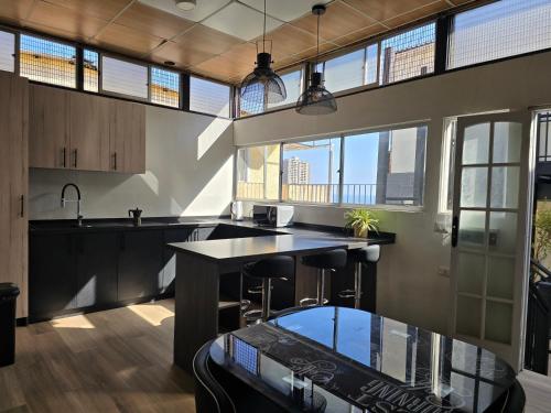 an open kitchen with a counter and some windows at AH Residencial in Antofagasta