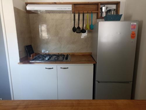 een keuken met een fornuis en een koelkast bij Casa en barrio tranquilo in Osorno