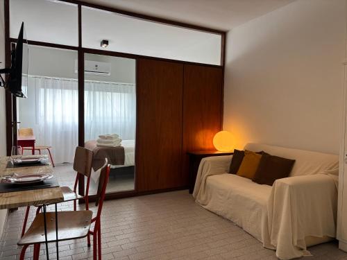 a bedroom with a bed and a table and a dining room at Minisuite Estación Ramos Mejía in Ramos Mejía