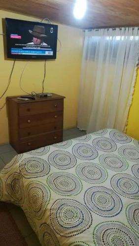 a bedroom with a bed with a tv on the wall at Cabaña recinto Super vista, WIFI con terraza4 in San Antonio