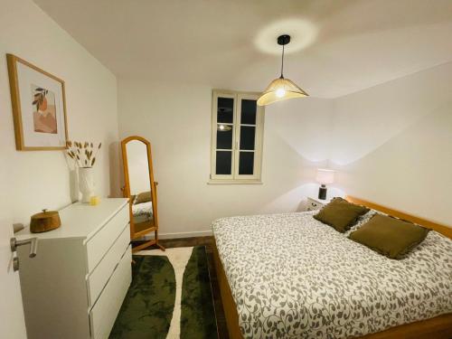 een slaapkamer met een bed, een ladekast en een raam bij Alsace's Home in Geispolsheim