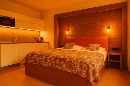 a hotel room with a bed and a kitchen at Apartmán Sivý vlk Hrebienok Rezort in Smokovce