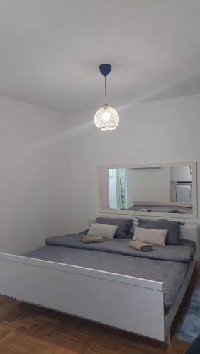 a bed in a room with a white wall at River stay in Sremska Mitrovica